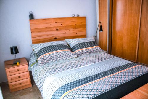 una camera con letto e testiera in legno di Apartamento Juan de Herrera a Málaga
