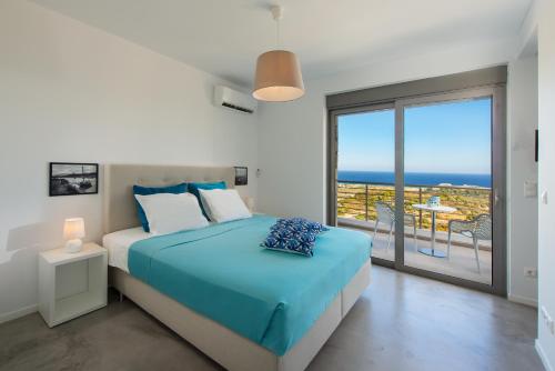 a bedroom with a bed with a view of the ocean at Villa Olympos in Afantou