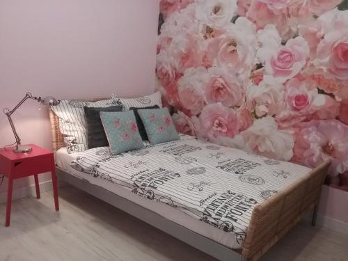 トルンにあるVINTAGE - ROSE APARTAMENTの花の壁のベッド1台が備わる客室です。