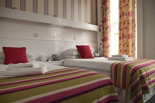 a bedroom with two beds and a window at Harry's Hotel & Restaurant in Aberystwyth