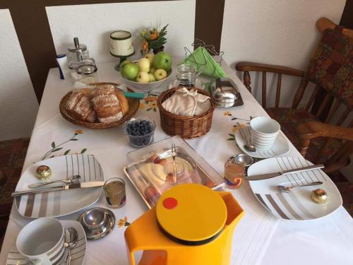 a table with a white table cloth with food on it at Pension Alois Hennecke in Schmallenberg