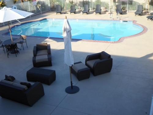 a patio with chairs and an umbrella and a pool at Howard Johnson by Wyndham Las Vegas near the Strip in Las Vegas