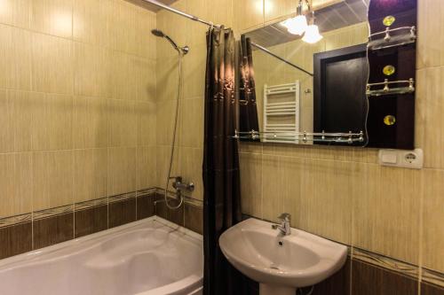 a bathroom with a sink and a bath tub at Apartment Gardens 44 in Tbilisi City