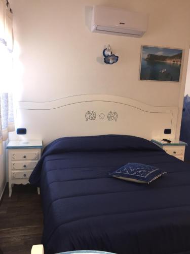 a bedroom with a blue bed and a night stand at B&B da Miranna in Dorgali