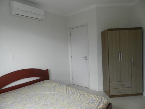 1 dormitorio con 1 cama y armario de madera en Reserva Jardim, en Bombinhas