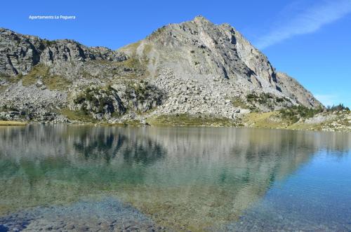 a mountain reflecting in the water of a lake at Apartaments la Peguera in Bohí