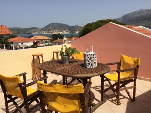 a table and chairs on the roof of a house at Wooden Roof Apartment in Lixouri