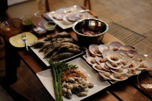a table topped with plates of food and mushrooms at Villa at Casalunar Bangsaen in Bangsaen