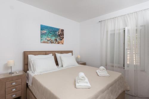 een slaapkamer met een bed met twee handdoeken erop bij Apartment Pavlović in Dubrovnik