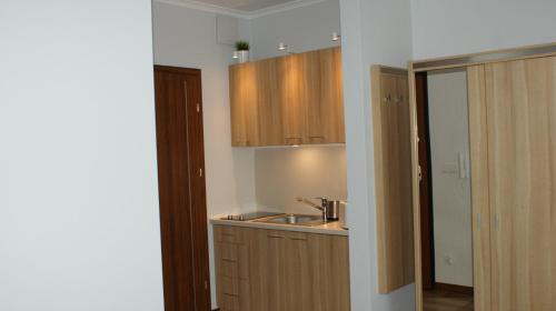 a kitchen with a sink and wooden cabinets at Apartament Magdalena in Świnoujście
