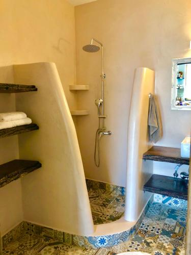a bathroom with a bath tub with a shower at Bekos traditional house in Archangelos