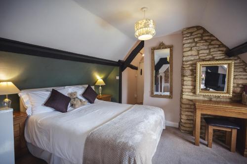 een slaapkamer met een bed met een teddybeer erop bij The Lamb Inn in Bourton on the Water