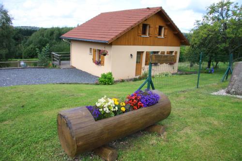 ein Haus mit einem Blumenpflanzer im Hof in der Unterkunft Gite De La Mortagne in Mortagne