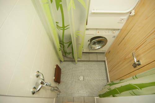 a small bathroom with a washer and a washing machine at A cozy wooden studio in a heart of Kharkiv in Kharkiv