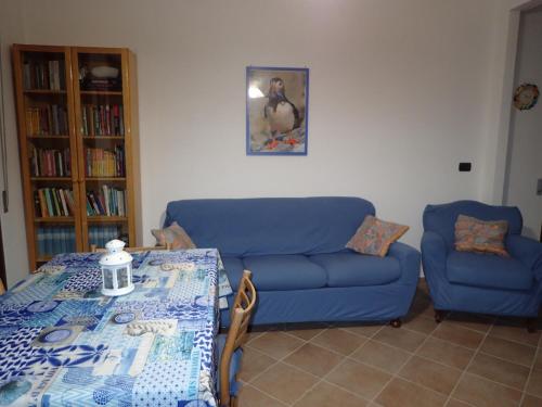 Una sala de estar con un sofá azul y una mesa. en Casetta al Mare, en Giustenice