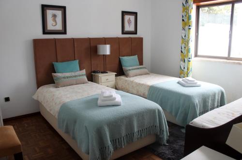 AmoreiraにあるVila Private Pool Beach Golf Praia Del Reyのベッドルーム1室(ベッド2台、窓付)