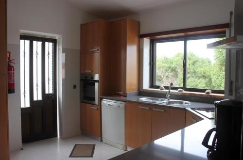 a kitchen with a sink and a window at Vila Private Pool Beach Golf Praia Del Rey in Amoreira