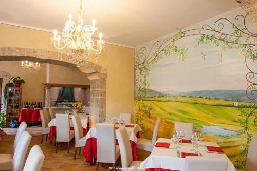 a dining room with white tables and a painting at Il Casale Della Regina in Arpino