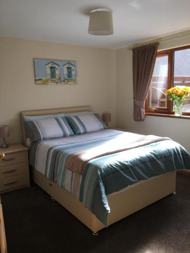a bedroom with a bed and a window at The Beachcomber in Inverallochy