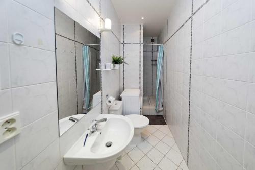 a white bathroom with a sink and a toilet at Apartment Na Kozacce 6 in Prague