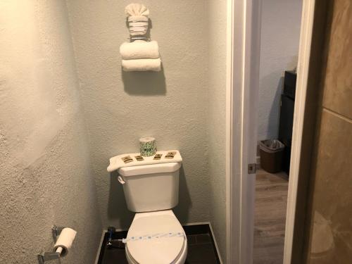 La petite salle de bains est pourvue de toilettes et de serviettes. dans l'établissement Relax Inn, à Flagstaff