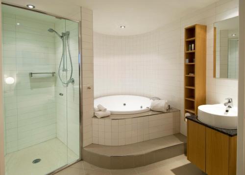a bathroom with a bath tub, toilet and sink at Rumba Beach Resort in Caloundra