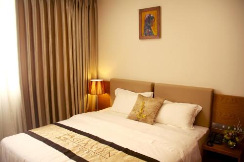 Un dormitorio con una cama con sábanas y almohadas blancas. en Gia Vien Hotel, en Ho Chi Minh