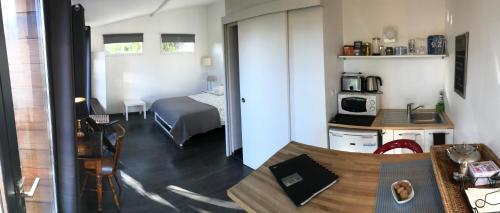a small room with a bed and a kitchen with a table at Chambre d'Hôtes du Clos Bamboo in Mérignac