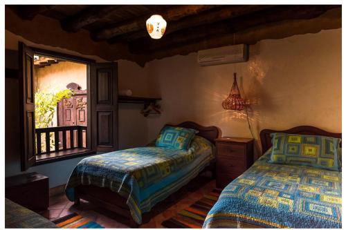a bedroom with two beds and a window at Hotel Boutique Quinta Tibigaro in San Vicente de Chucurí