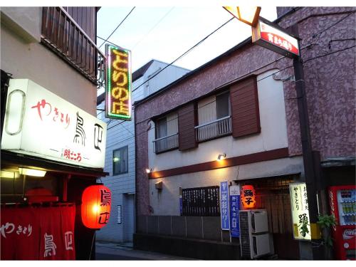 a building with a neon sign on a street at Izu no ie MOANA in Ito