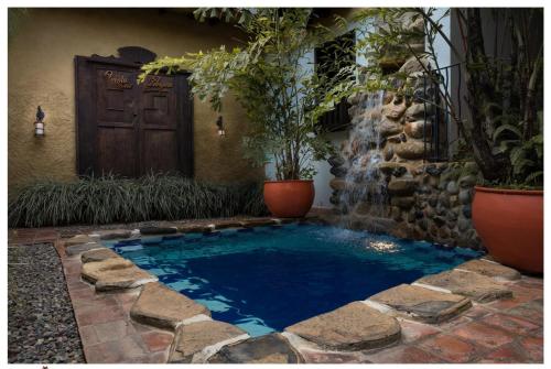 a small swimming pool with a waterfall in a yard at Hotel Boutique Quinta Tibigaro in San Vicente de Chucurí