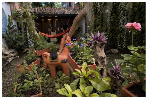 a garden with a statue in the middle of some plants at Hotel Boutique Quinta Tibigaro in San Vicente de Chucurí