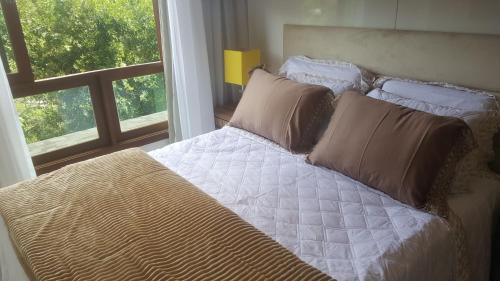 a bed in a bedroom with a window at Loft luxo em Pedra Azul in Pedra Azul