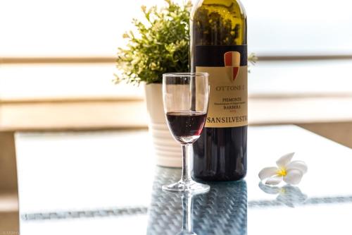 a bottle of wine and a glass on a table at Sandy Beach Condo 17D in Cha Am