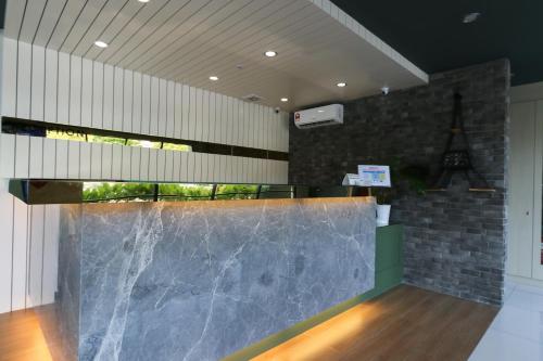 a lobby with a large marble counter in a building at Hotel 99 Kota Kemuning in Shah Alam