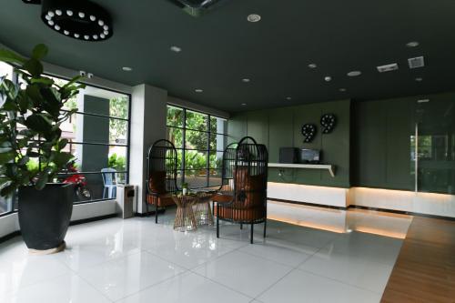 a living room with a table and chairs and windows at Hotel 99 Kota Kemuning in Shah Alam