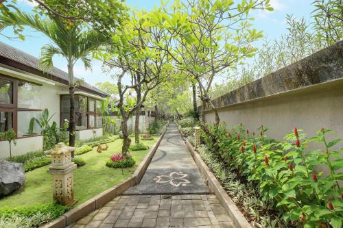 a path in a garden with trees and plants at Lumbini Luxury Villas and Spa in Jimbaran