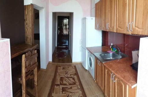una cucina con armadi in legno e lavandino di Apartment on Zarvanskaya in Old Town a Kam"janec'-Podil's'kyj