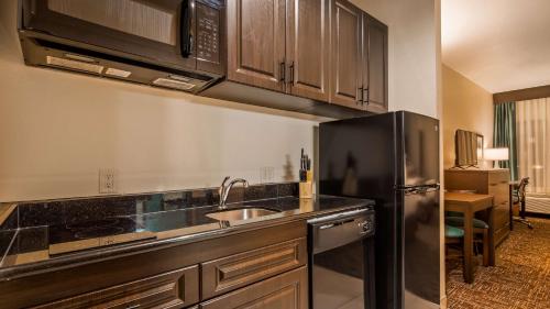 a kitchen with a sink and a refrigerator at Best Western Plus/Executive Residency Elk City in Elk City
