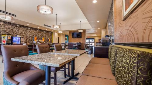 a restaurant with two tables and chairs and a counter at Best Western Plus/Executive Residency Elk City in Elk City