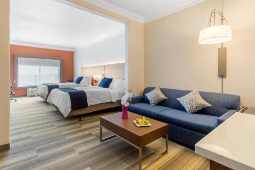 een hotelkamer met een bed en een blauwe bank bij Holiday Inn Express Houston-Alvin, an IHG Hotel in Alvin