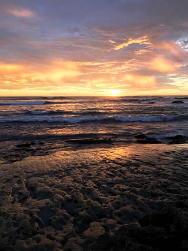 a sunset over the ocean on a beach at Tamarindo Sunshine in Tamarindo