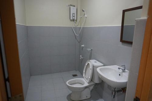 a bathroom with a toilet and a sink at Alimpay Foresters Apartment in Panglao