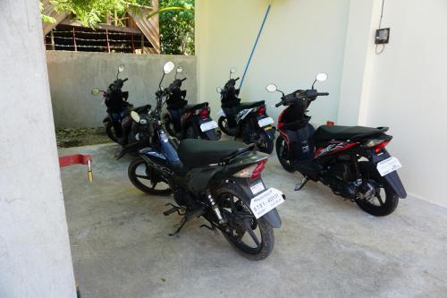 a row of motorcycles parked next to a wall at Alimpay Foresters Apartment in Panglao