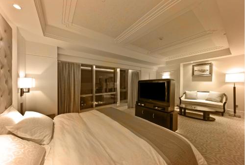 a bedroom with a large bed and a television at Paramount Gallery Hotel in Shanghai