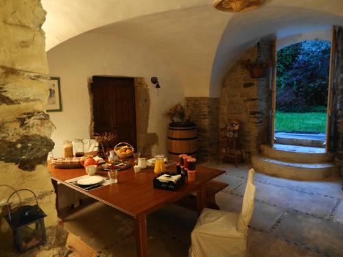 a dining room with a table and a stone wall at La Maison d'hôtes in Le Poujol-sur-Orb