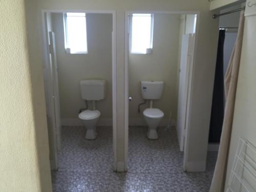 a bathroom with two toilets and two windows at Accommodation @ Isa in Mount Isa