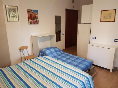 a small bedroom with a bed and a refrigerator at Casa Vittoria in Gaeta
