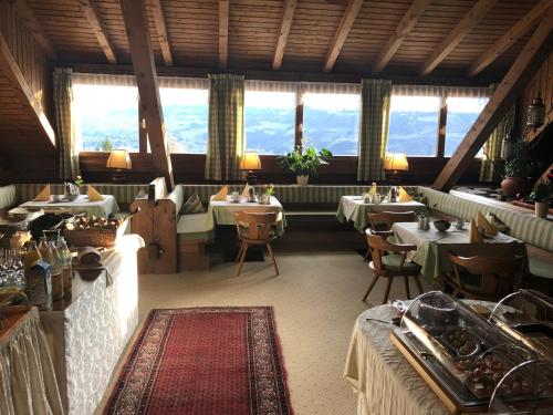 a restaurant with tables and chairs and windows at Hotel Garni Vigilhof in Lana