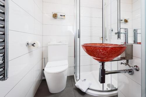 a bathroom with a red sink and a toilet at RQ Boutique & Unique Hotel in Győr